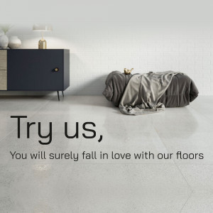 Person playfully falling onto a light-colored floor with text 'Try us, You will surely fall in love with our floors'