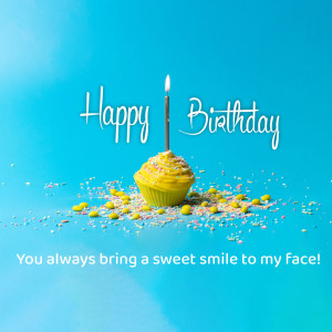 A yellow frosted cupcake with a lit candle and sprinkles, with the text 'Happy Birthday' and 'You always bring a sweet smile to my face!'