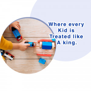 Two children's hands playing with colorful wooden toy cars and blocks on a wooden floor.