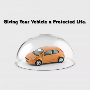 A miniature orange car inside a clear protective dome.