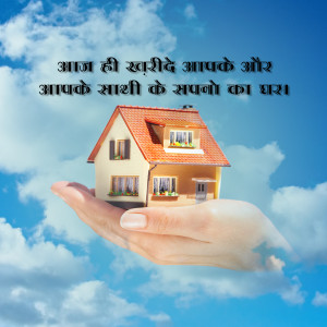 A miniature house held in a hand against a blue sky with clouds.