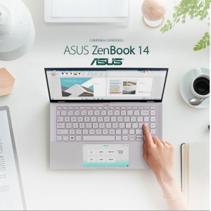 Overhead view of an ASUS ZenBook 14 laptop in use with coffee and office supplies.