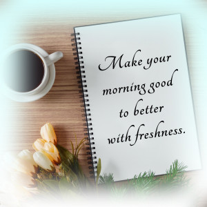 Open notebook with motivational quote, coffee cup, and tulips on a wooden surface.