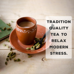 A cup of traditional Indian chai (tea) served in an earthen cup with cardamom pods.