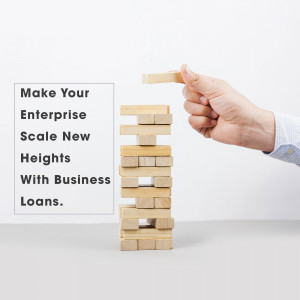 Hand removing a block from a wooden tower, symbolizing business growth and risk.