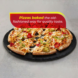 Close-up of a pepperoni pizza with fresh toppings on a slate serving board.