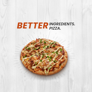 Close-up of a delicious pizza with fresh ingredients on a white wood background.