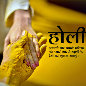 Hands covered in yellow Holi powder with the word 'Holi' in Devanagari script.