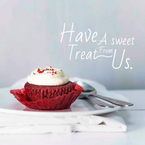 Close-up of a red velvet cupcake with white frosting on a white plate.