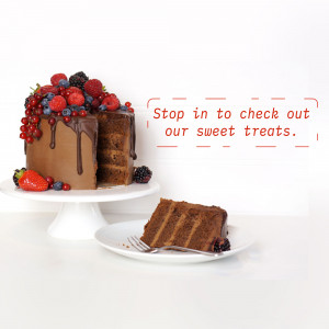 A chocolate cake topped with fresh berries and a slice on a plate.