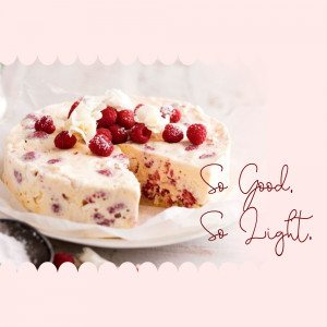 A slice of raspberry white chocolate cheesecake with fresh raspberries and whipped cream.