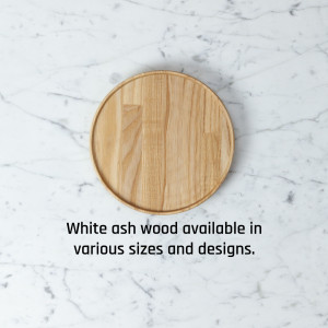 Close-up of a round wooden coaster on a white marble background with text.