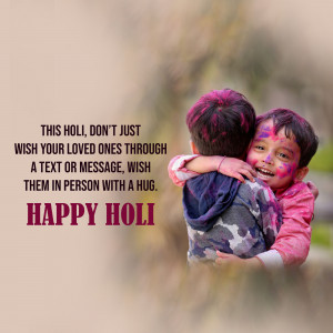 Two children embracing and covered in colorful powder during Holi festival.
