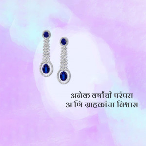 Close-up of silver dangle earrings with blue sapphire stones against a soft pink background.