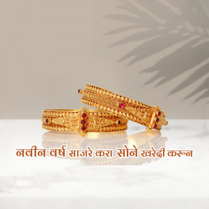 Close-up of two ornate gold bangles with red stone accents on a reflective surface.