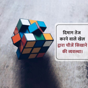 A Rubik's Cube resting on a textured surface next to a sign with text in Hindi.