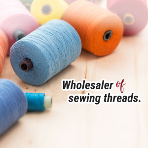 Close-up of various colorful spools of sewing thread with text 'Wholesaler of sewing threads.'