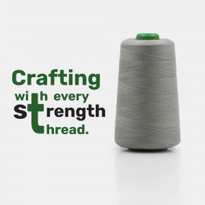 Spool of gray thread with the text 'Crafting with every strength thread'