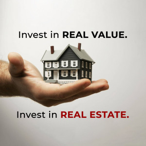 A hand holding a miniature house, symbolizing real estate investment.