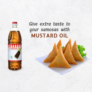 A bottle of mustard oil next to a plate of golden-brown samosas.