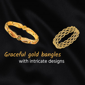 Close-up of two ornate gold bangles on a black silk background