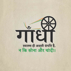 Image of Mahatma Gandhi's spinning wheel (Charkha) with text in Hindi and Devanagari script.