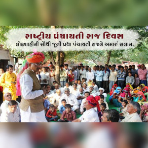 Group of people with a man in a traditional Rajasthani turban celebrating National Panchayati Raj Day.