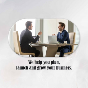 Two business professionals discussing strategy with laptops at a modern conference table.