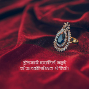 Close-up of a gold ring with a large blue sapphire and surrounding diamonds on a red silk background.