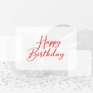 A white card with red cursive text that says 'Happy Birthday' resting on a textured surface.