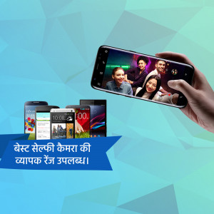 Hand holding a smartphone displaying a group selfie, with other smartphones in the background and text in Hindi.