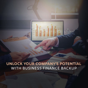 Two people discussing financial charts and data on a laptop and documents.