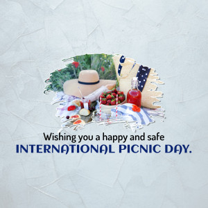 Picnic basket with strawberries, hat, and a bottle of juice with a 'Happy International Picnic Day' message.