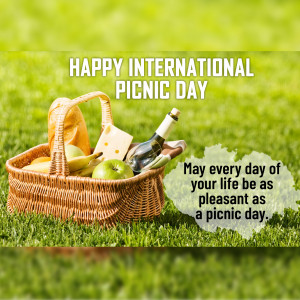 Picnic basket with food and wine on green grass, celebrating International Picnic Day.