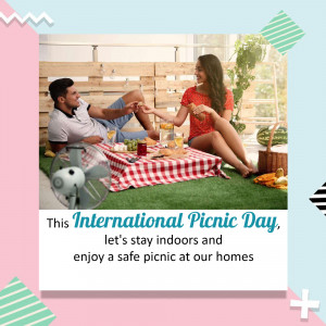 Couple enjoying a picnic indoors with food and drinks.