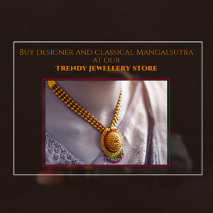 Close-up of a gold mangalsutra with a red and green stone pendant on a silk background.