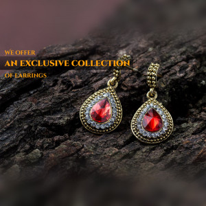 Close-up of ornate gold earrings with red gemstones