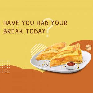 Two golden-brown samosas on a white plate with a side of red sauce.