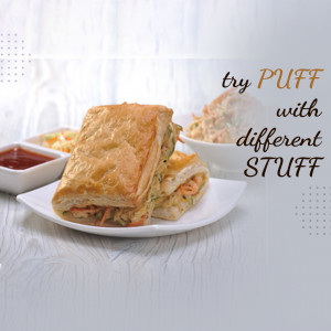 Close-up of a puff pastry sandwich with a side of sauce