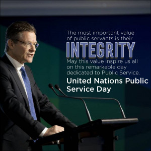 Man speaking at a podium with text about integrity and United Nations Public Service Day.