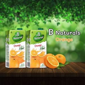 Two cartons of B Naturals Orange Juice with oranges and green leaves on a wooden surface.