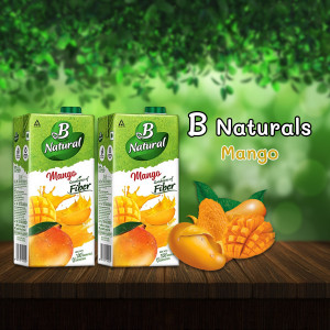 Three cartons of B Naturals Mango Juice with fresh mangoes