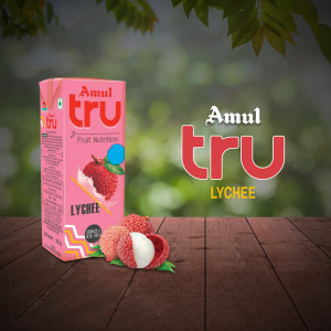 Amul Tru Lychee flavored fruit drink in a carton with fresh lychees