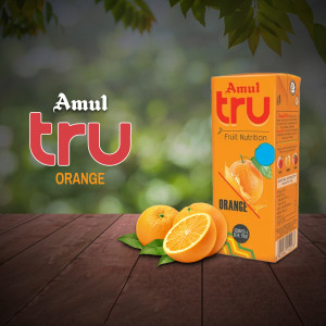 Amul Tru Orange Juice carton with oranges and leaves on a wooden surface