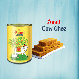 A can of Amul Cow Ghee with pieces of ghee on a white surface.
