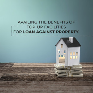 Image depicting a house model on top of stacks of money, representing loan against property top-up facilities.