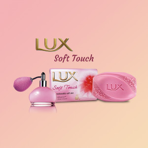 Lux Soft Touch soap with perfume bottle on a pink background