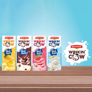 Four cartons of Britannia Winkin' Cow Thick Shakes in different flavors displayed on a wooden surface.
