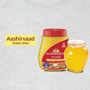 Aashirvaad Swasti Ghee in a jar with a small glass of ghee beside it.