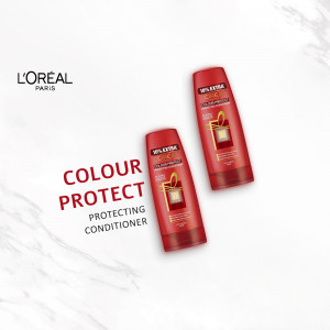 Two bottles of L'Oréal Colour Protect Protecting Conditioner against a marble background.